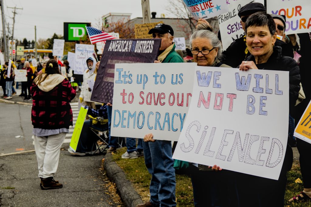 Protesters line the sidewalks and hold signs during the No Kings protest in Presque Isle, Maine, on October 18th, 2025.