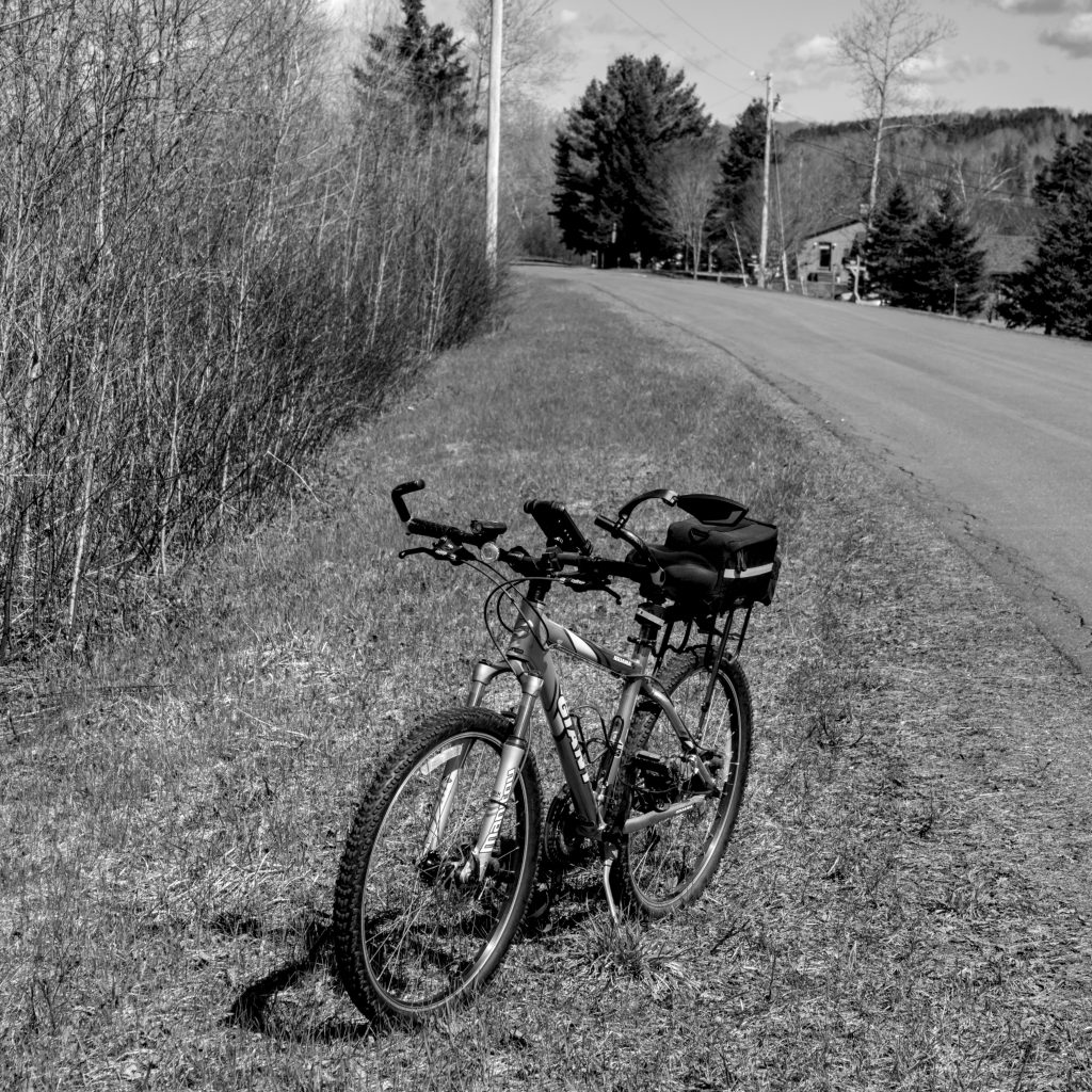 A mountain bike parked on the side of the road.