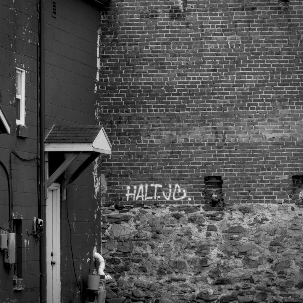 Graffiti marks the corner where these two buildings meet.