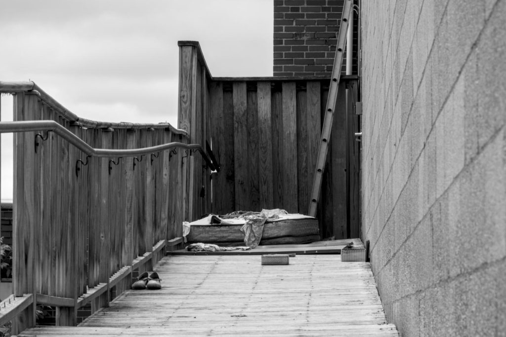 A mattress on an old wooden walkway.