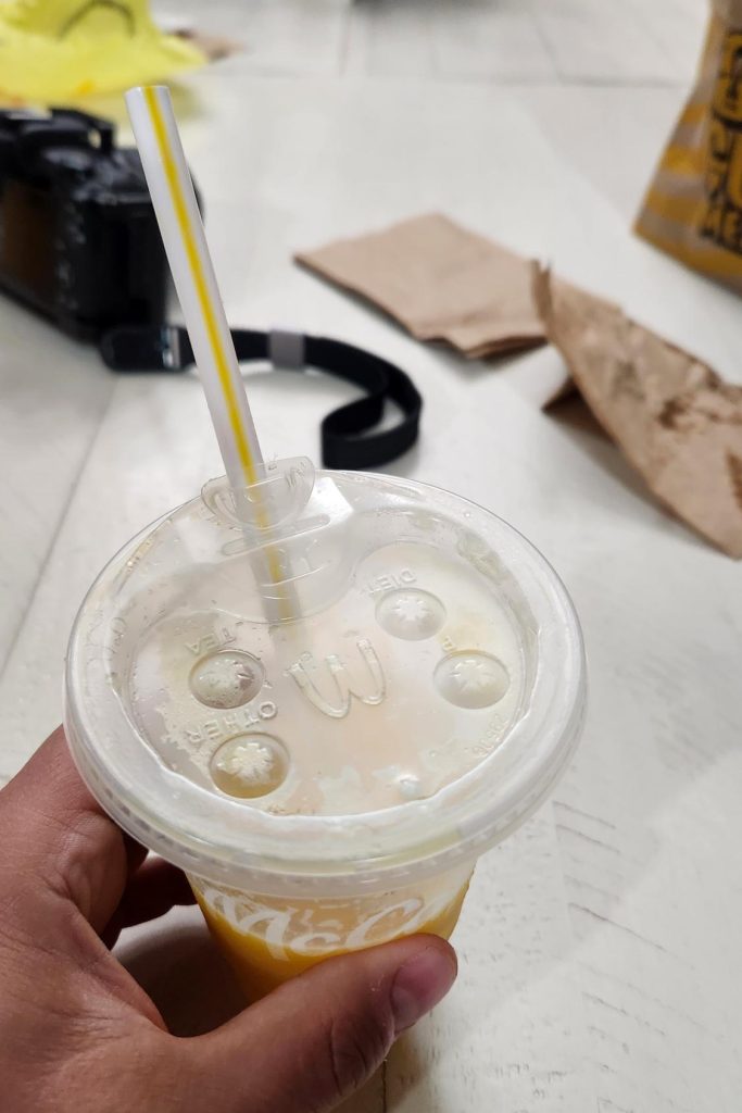 A cup of McDonalds orange juice facing the wrong way.