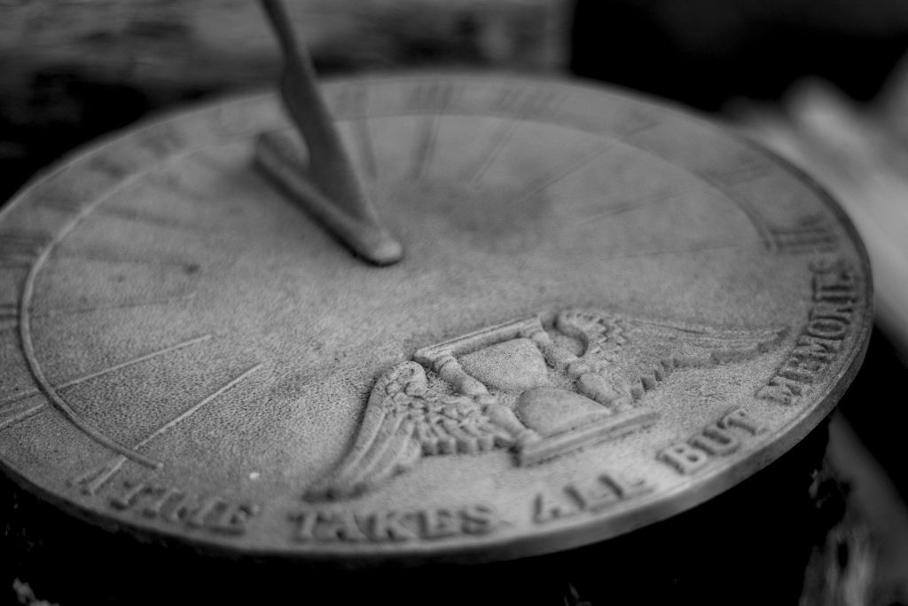 A closeup black and white photo of a sundial. 